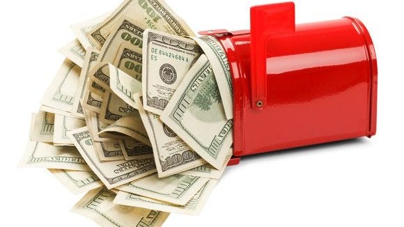 red mailbox stuffed with hundred dollar bills that are almost spilling out